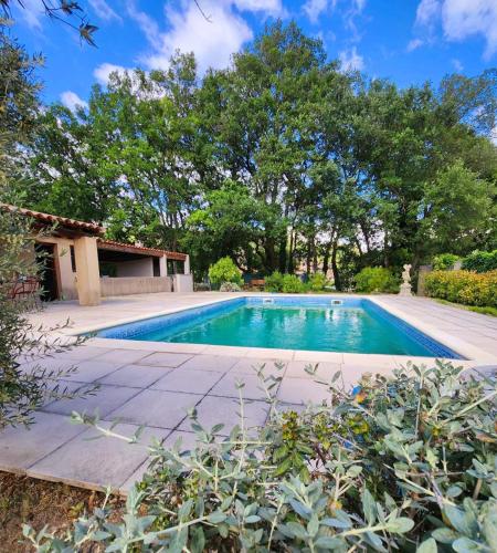 a swimming pool in a yard with a house at Le Clos Renaissance in Oppède