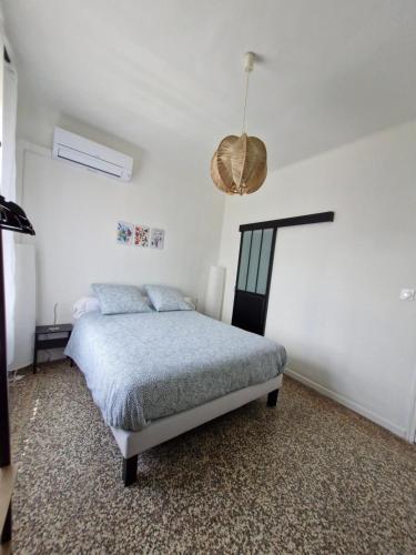 a bedroom with a bed and a pendant light at Chambre Sommières in Sommières