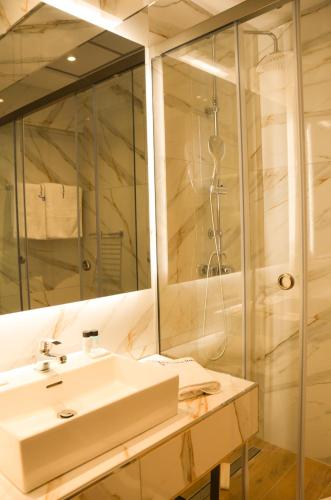 a bathroom with a sink and a shower at Odysseus Hotel in Paleokastritsa