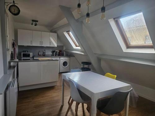 une cuisine avec une table et des chaises dans une pièce dans l'établissement Le Port Vauquelin, à Dieppe