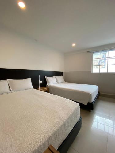 a bedroom with two beds and a window at Apartahotel Marbella in San Andrés