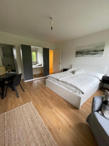 a bedroom with a large white bed and a desk at Appartamento La Torretta in Locarno