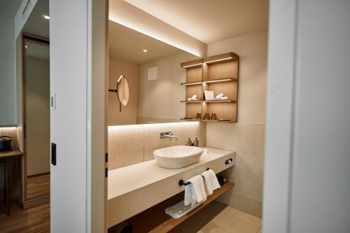 W łazience znajduje się umywalka i lustro. w obiekcie Nouri w mieście Bad Krozingen