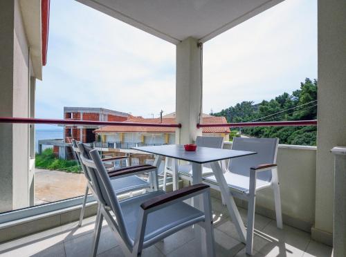 una mesa y sillas en un balcón con vistas en Elpiniki Luxury Rooms, en Nea Potidaea