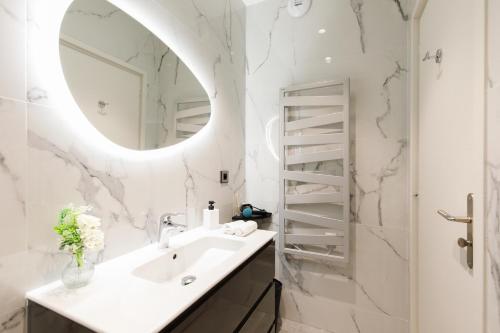 une salle de bain avec un lavabo et un miroir dans l'établissement 06AG - Bel appartement proche Palais des Festivals, à Cannes