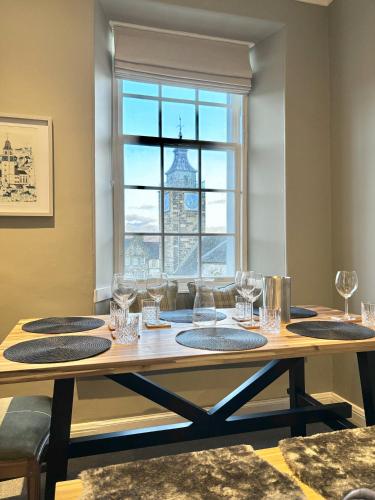 a dining room table with glasses and a window at St Johns Jailhouse by the Castle in Stirling