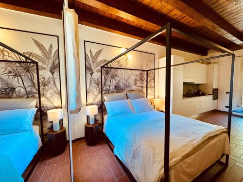 a bedroom with two beds with blue sheets and a mural at Slim Apartment#20 - Montorfano Lake in Montorfano