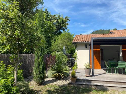 a garden with a patio and a house at La Petite Caserne - Gite 4 étoiles - in Pont-de-Labeaume