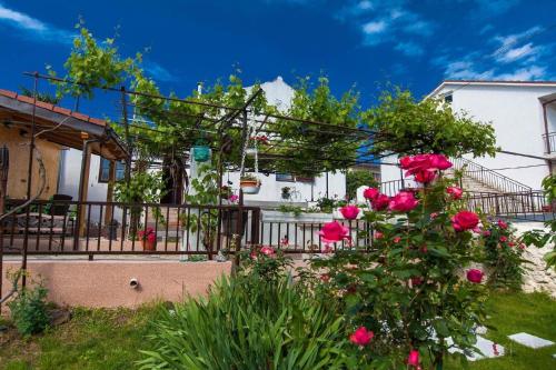a garden with roses in front of a house at Ferienhaus für 4 Personen ca 62 qm in Crikvenica, Kvarner Bucht Crikvenica und Umgebung in Crikvenica