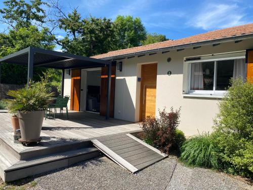 a house with a deck with a black umbrella at La Petite Caserne - Gite 4 étoiles - in Pont-de-Labeaume