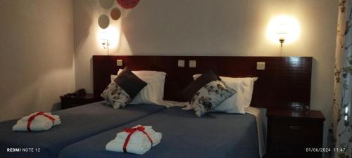 a hotel room with two beds with pillows at Hotel Alnacir in Faro