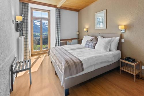 a bedroom with a large bed and a large window at Le Saint Georges in Gruyères