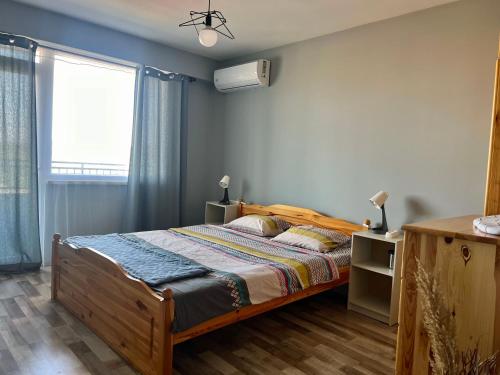 um quarto com uma cama e uma janela em Тристаен апартамент Park View em Targovishte