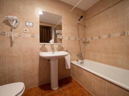 een badkamer met een wastafel, een toilet en een bad bij Casa Cambra in Aínsa