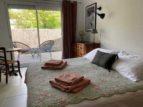 1 dormitorio con 1 cama con 2 toallas en La Petite Caserne - Gite 4 étoiles -, en Pont-de-Labeaume