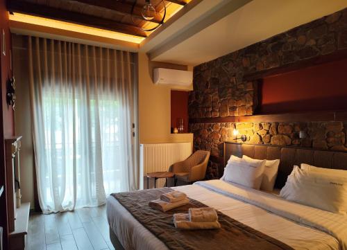 a hotel room with a bed and a stone wall at Ζέον Ύδωρ in Órma