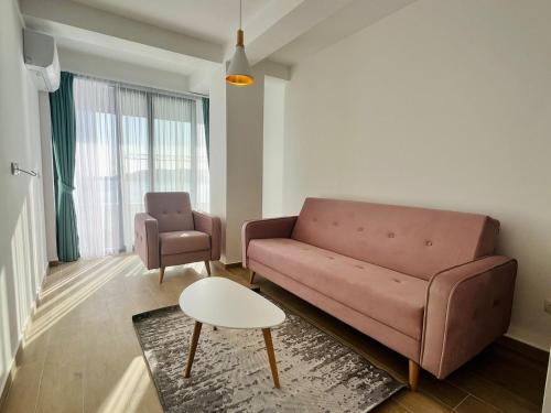 a living room with a couch and a chair at Rafailovici Beachfront Apartment in Budva