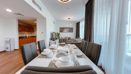 a dining room with a long table and chairs at Luxury Apartments - Ajman Corniche UAE in Ajman