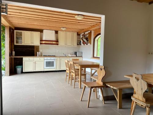 una cucina con armadi bianchi, tavolo e sedie di Wooden Cabin Kamna Gorica a Kamna Gorica