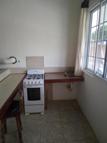 a kitchen with a stove and a sink next to a window at Comfort rooms in Content