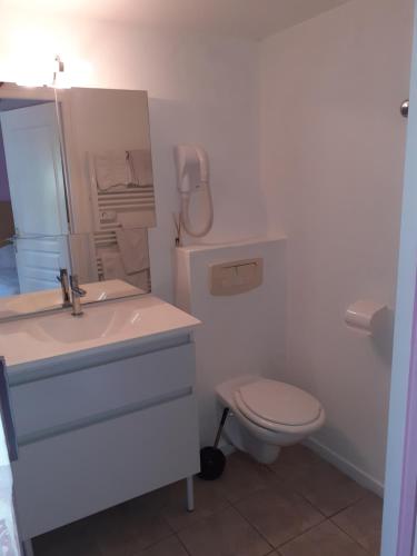 a bathroom with a sink and a toilet and a phone at Gîte 1 in Rogny