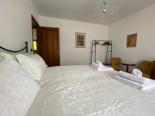Un dormitorio con una gran cama blanca con toallas. en La Foresteria, en Feletto Umberto