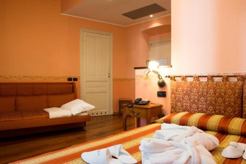 Habitación de hotel con cama y sofá en Hotel Belle Epoque, en San Remo
