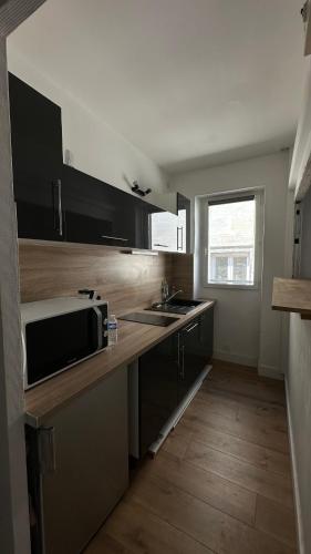 une cuisine avec un évier et un micro-ondes dans l'établissement Studio in the historical city center, à Avignon