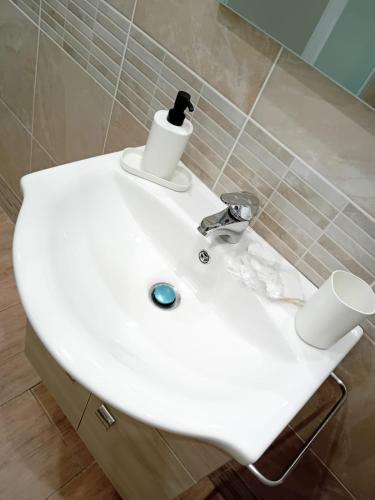 a white bathroom sink with a soap dispenser on it at Vama House in Naples