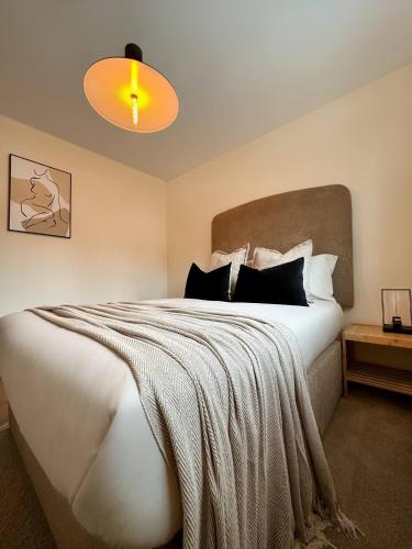Un dormitorio con una gran cama blanca y una lámpara en Scandinavian Haus For 8 en Mánchester