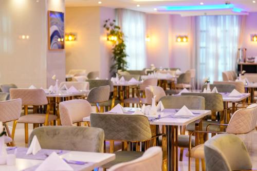 a dining room with tables and chairs with napkins at Paradise Nice Hotel Jeddah in Jeddah