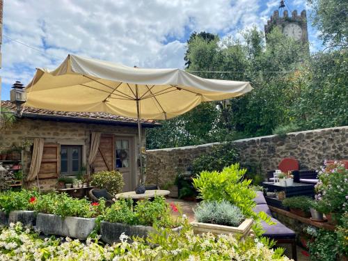 un patio con sombrilla frente a una casa en La Magione dei Todaro, en Borgo a Buggiano