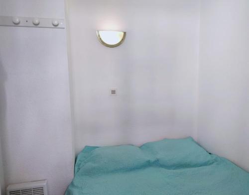 Cette chambre comprend un lit avec une lampe et un miroir. dans l'établissement Zenitude Corniche charmant studio cabine vue mer, à Sète