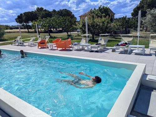 a man is swimming in a swimming pool at Il Granaio in Porto SantʼElpidio