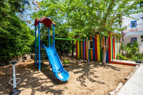 a playground with a slide in front of a house at Paloma Family Club in Bitez