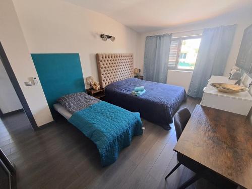 a small room with two beds and a table at Villa Ocean Waves in Aroeira