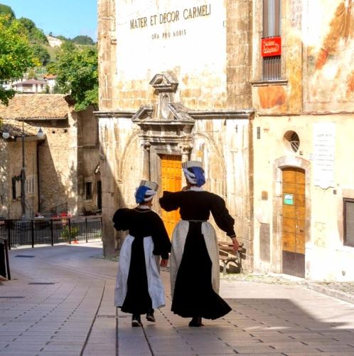a painting of two people standing in front of a building at Room La Vicenna in Scanno