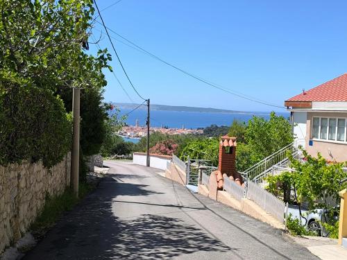 an empty street with a house and the ocean at Panoramic view studio in Rab