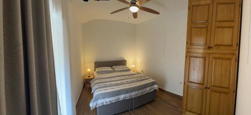 a bedroom with a bed and a ceiling fan at Apartments F&T in Mošćenička Draga