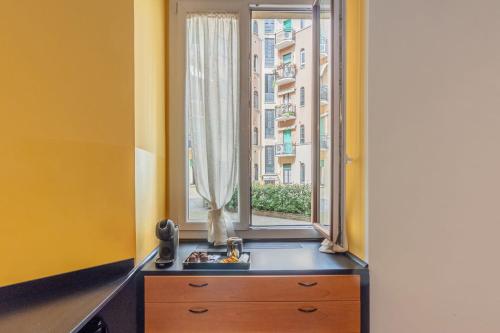 Homeby - Appartamento Simonetta - Porta Romana في ميلانو: نافذة في غرفة مع خزانة ملابس أمامه