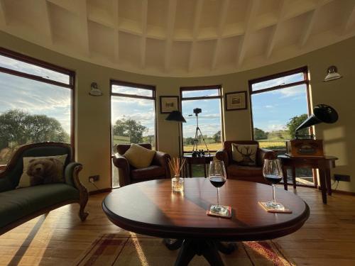 a living room with a table and two glasses of wine at Luxury Escape with Hot Tub in County Antrim in Kells