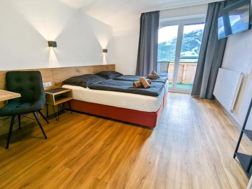 1 dormitorio con cama, escritorio y silla en Appartement Haus Talblick, en Kaprun