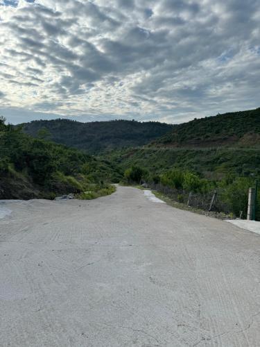 an empty road in the middle of a mountain at Qyteza Guest House & Camping in Renc
