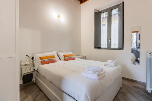 een witte slaapkamer met een groot bed met handdoeken erop bij Homeby - Apartment Anna Maria in Corsico