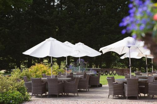 a group of tables and chairs with umbrellas at Bartley Lodge Hotel in Lyndhurst
