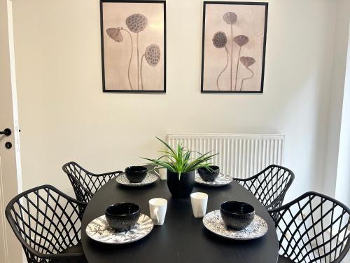 a black table with four chairs with cups and bowls on it at Friends & Family Brussels Atomium 6-8 pers in Grimbergen