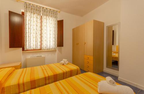 una camera da letto con due letti e una finestra di Residence L'Uliveto a Mattinata