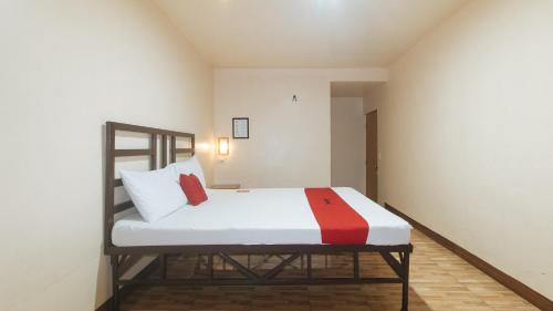 a bedroom with a bed with white and red pillows at RedDoorz at Elegance Guest House near NAIA T3 in Manila