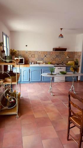 Il comprend une cuisine avec des placards bleus et du carrelage. dans l'établissement Maison provençale les glycines, à Roquemaure