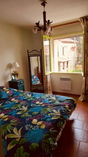 une chambre avec un lit, une fenêtre et un miroir dans l'établissement Maison provençale les glycines, à Roquemaure